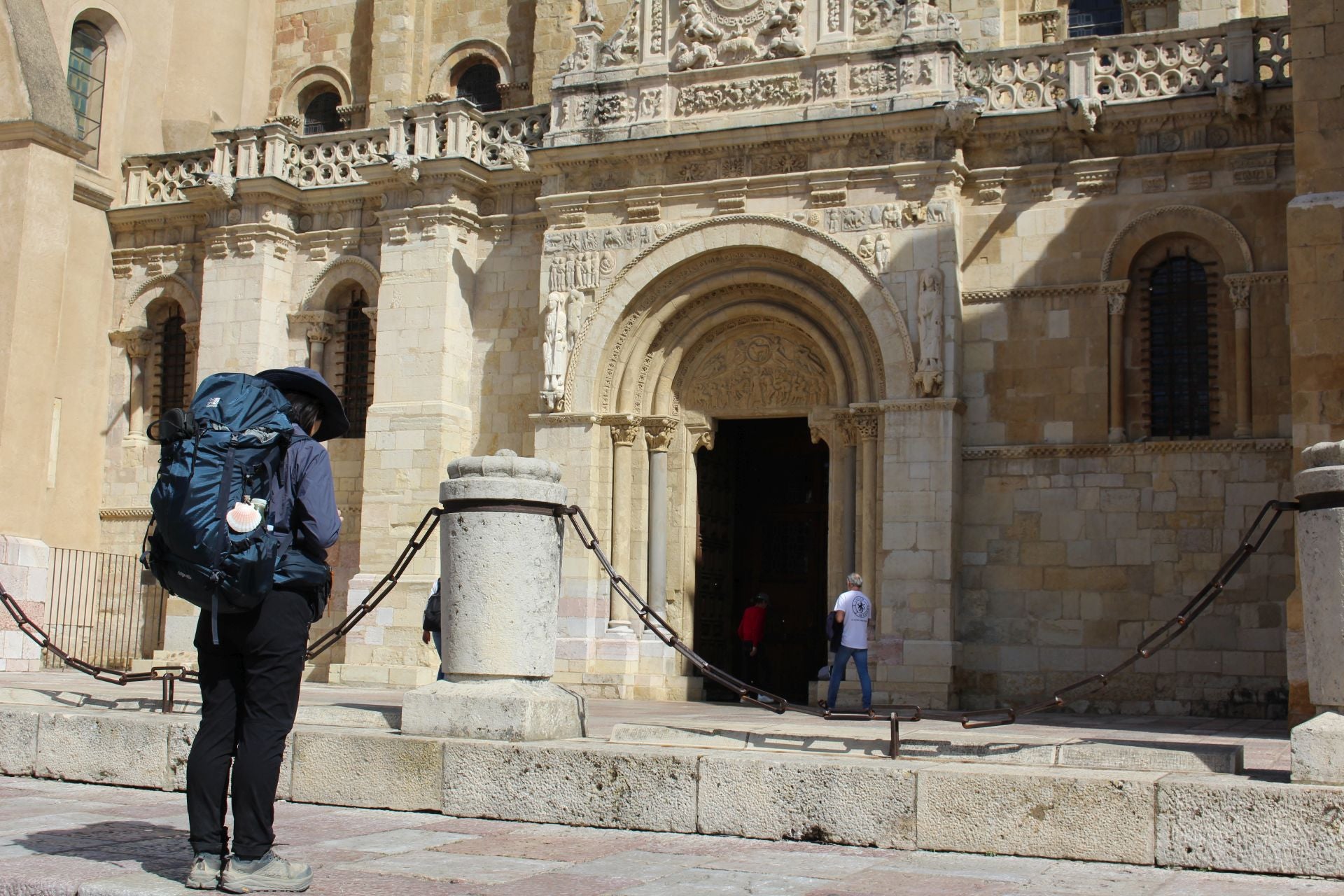 Una peregrina del Camino de Santiago en su etapa por León se para frente a San Isidoro.