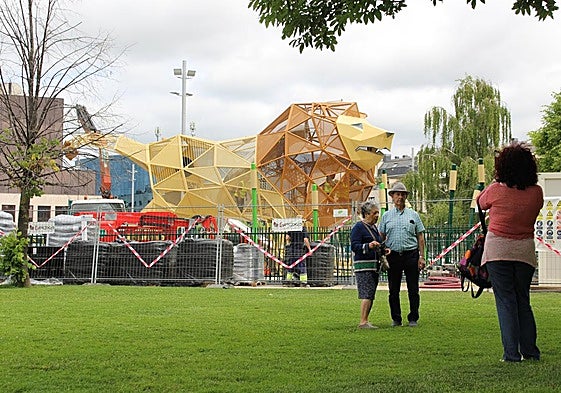 Una pareja de jubilados se saca una foto junto al león de la explanada de los Pendones Leoneses.
