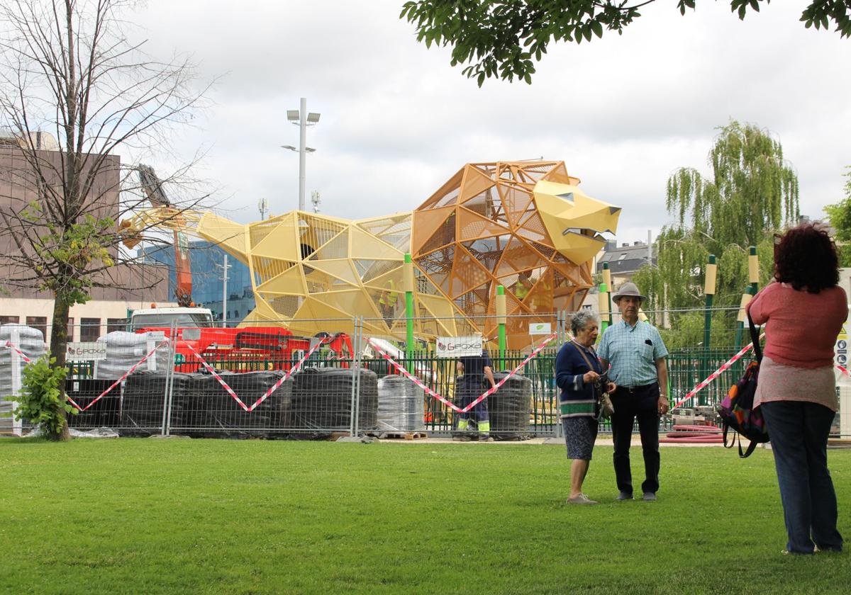 Una pareja de jubilados se saca una foto junto al león de la explanada de los Pendones Leoneses.