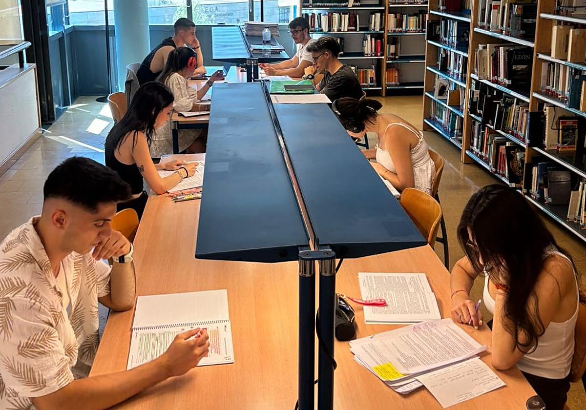 Imagen de opositores con apuntes en mesas de estudio.