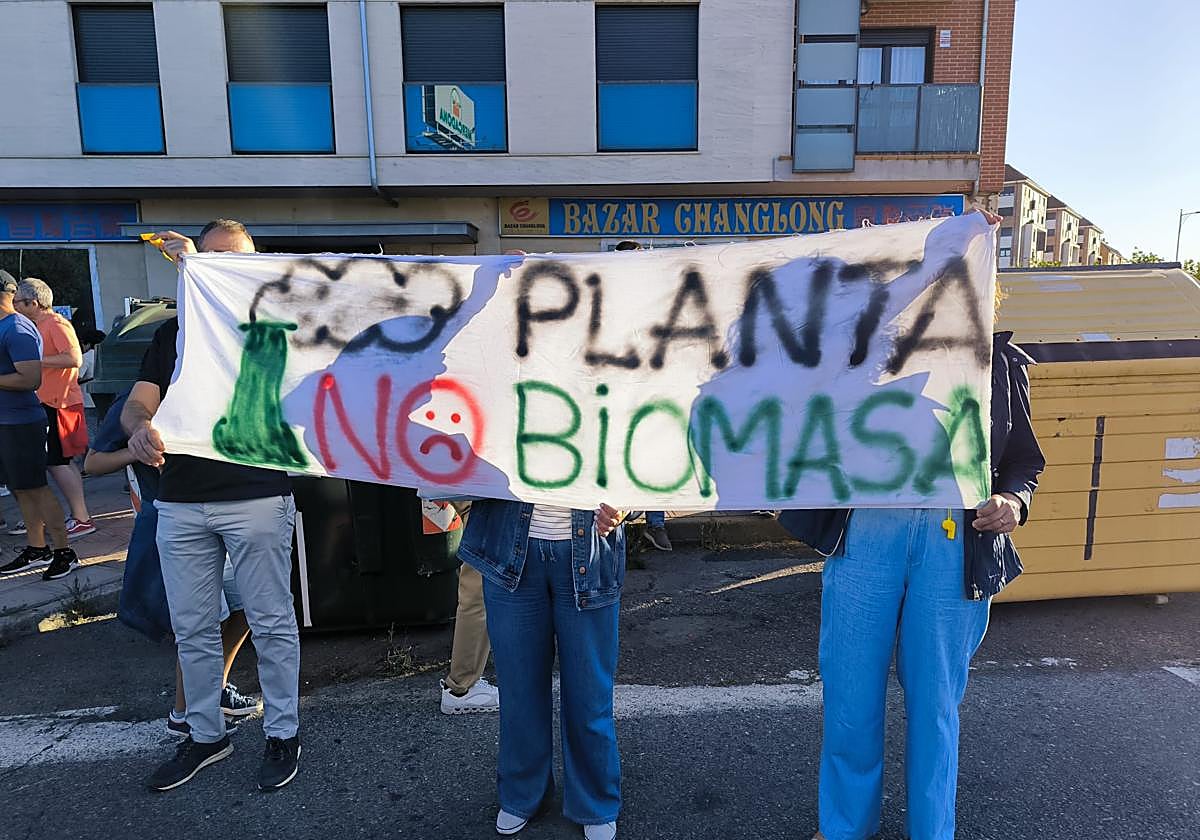 Varios manifestantes sostienen una pancarta contra la instalación de la planta de biomasa.
