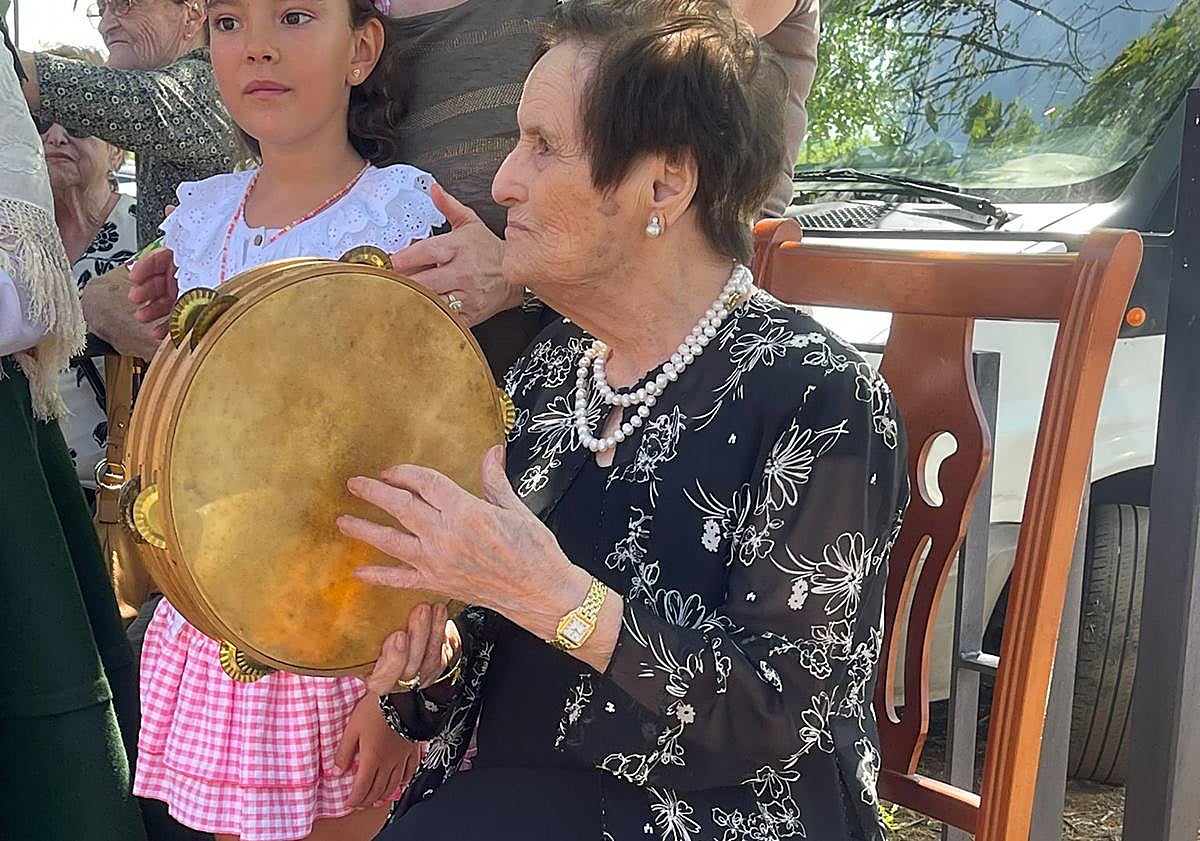 Imagen principal - Teresa con su pandereta y el libro en el que aparece su historia.