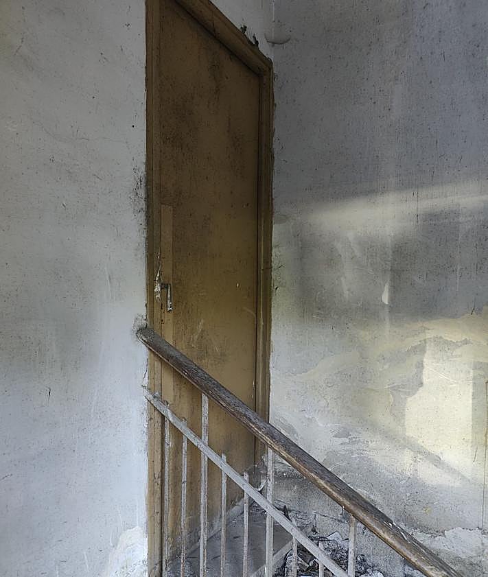 Imagen secundaria 2 - El edificio de Bodegas Armando, la zona en la que habitan los okupas actuales y la puerta por la que acceden.