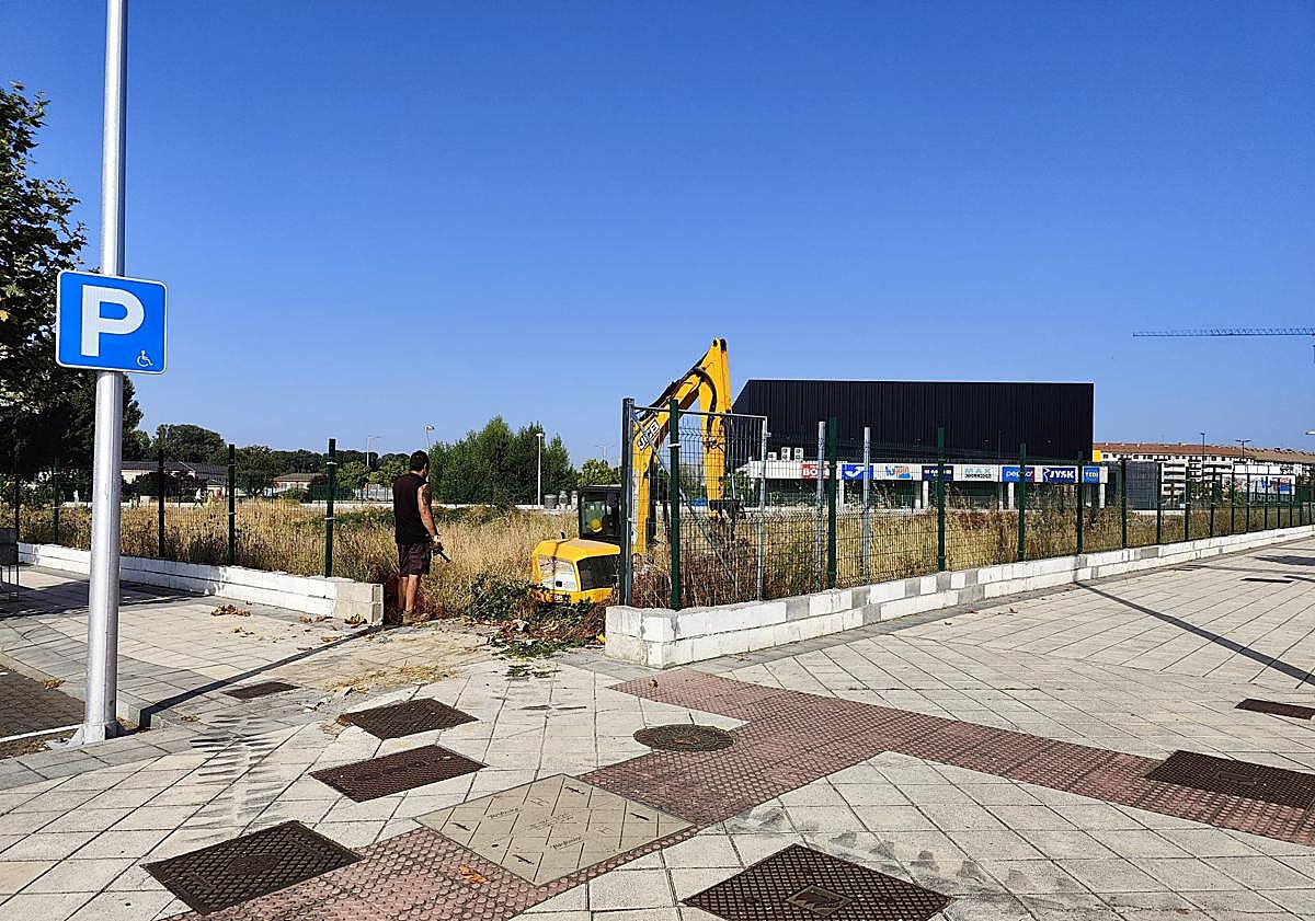 Imagen principal - Un solar vallado en el que se realizan labores de limpieza; uno sin vallar con otro cerrado al fondo; y uno sin cercado y limpio a ras de suelo.