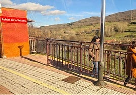 Tren de vía estrecha en León y viajeros saliendo de la estación.