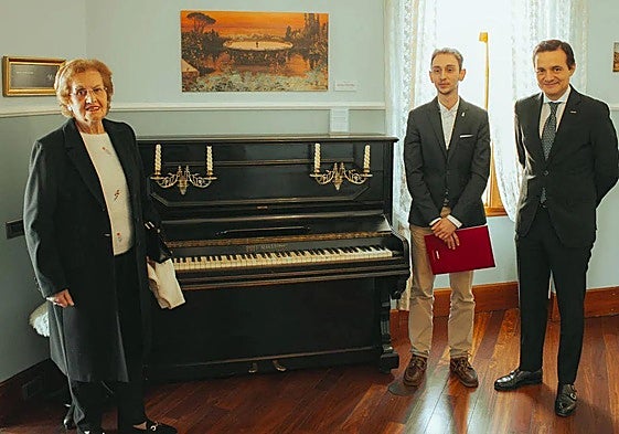 Imagen de archivo de Emilia Fernández Díez, donante, Carlos Varela, conservador jefe del Museo Casa Botines Gaudí y Raúl Fernández Sobrino, director del Museo, posan con el piano colocado en la recreación de la vivienda.