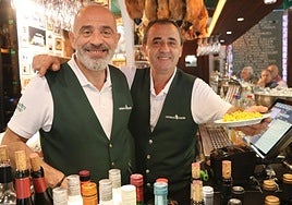 Imagen de dos de los camareros del establecimiento con la tapa de paella.