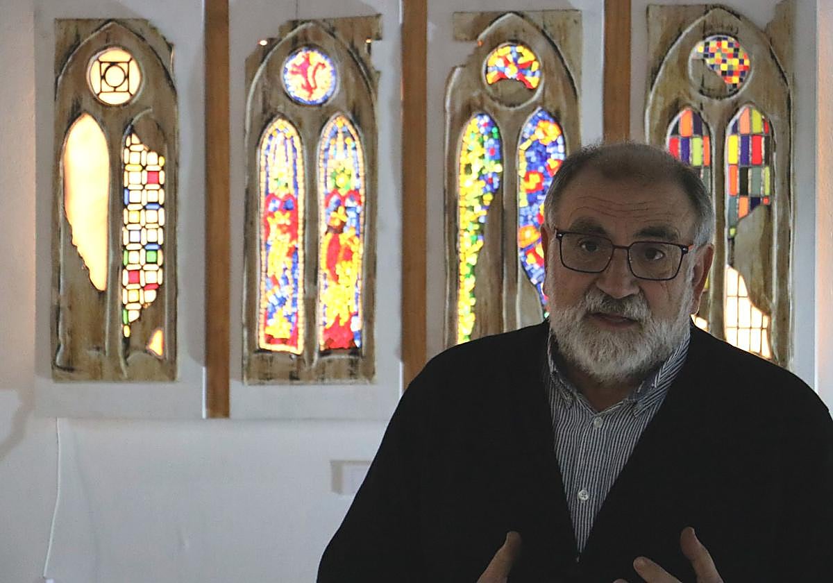 Julio Bernabé y, de fondo, un ejemplo de su obra hecha en vidrio.