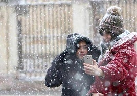 Dos jóvenes bajo la nieve en León.