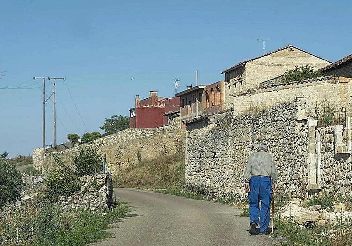 Un jubilado pasea por su pueblo en la provincia de León.