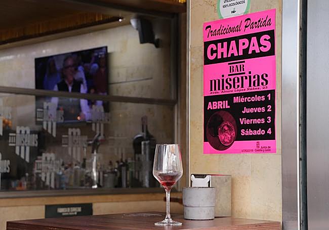 Acceso al bar Miserias con el cartel que anuncia las chapas esta Semana Santa en León.