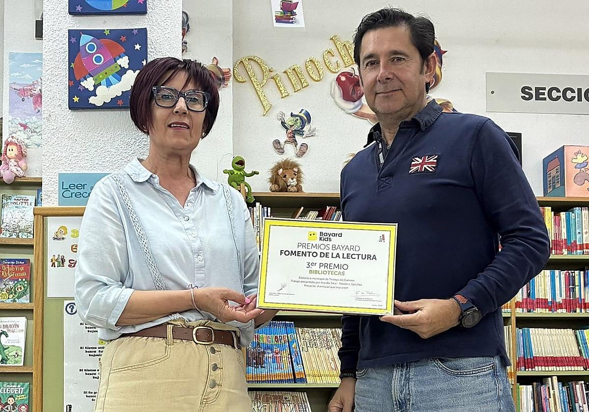 Los responsables con el premio que ha recibido la biblioteca.