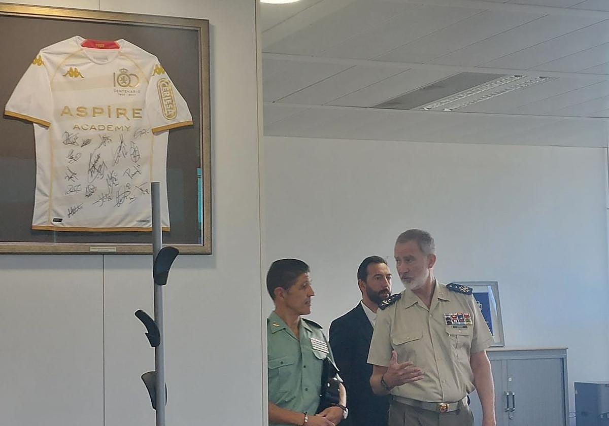 El rey pasa junto a de una camiseta de la Cultural.