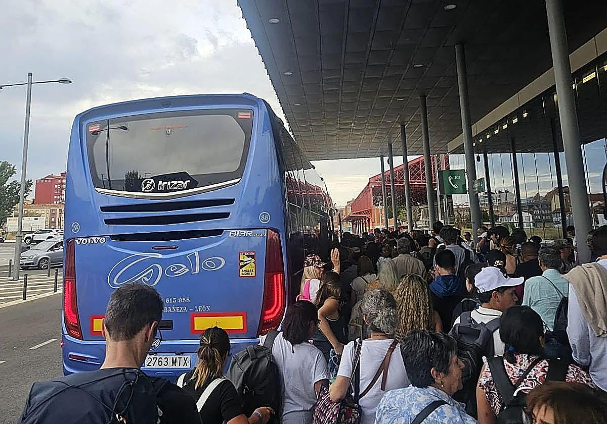 Viajeros en la estación de León, tratando de subirse a uno de los autobuses.