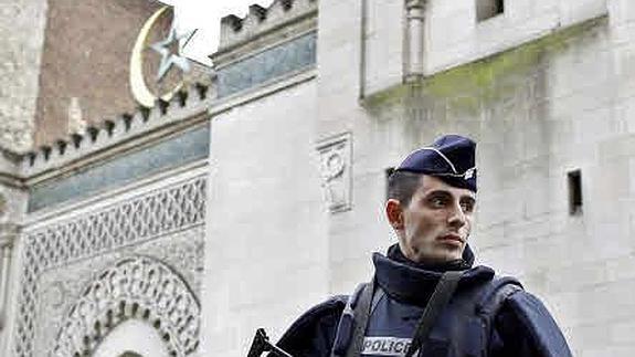 Un Policía francés vigila la entrada a una mezquita de París.