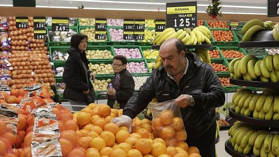 Un grupo de personas haciendo la compra en un supermercado. 