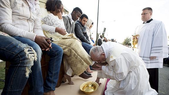 El papa Francisco besa los pies de una refugiada.