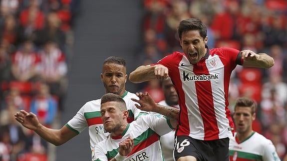 Rober, del Granada, disputa un balón con Etxeita, del Athletic. 