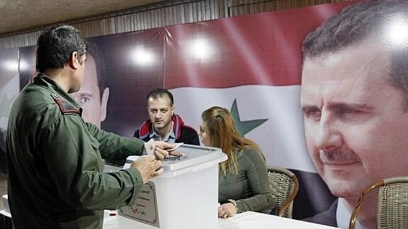 Un soldado deposita su voto en la urna en un colegio electoral en Damasco. 