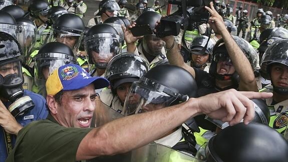 El líder opositor Henrique Capriles (i) habla ante la Policía venezolana durante una manifestación.