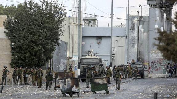 Soldados toman posiciones durante las protestas contra el asesinato de un joven palestino por el Ejército israelí. 