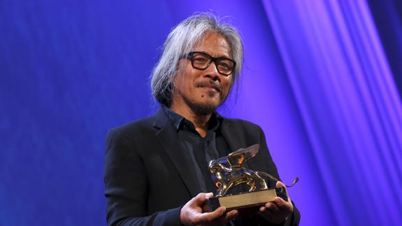 El cineasta filipino Lav Diaz posa con el León de Oro del Festival de Venecia.