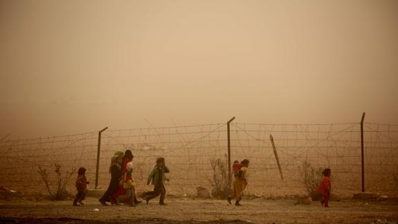 Niños sirios caminando por campamento en Raqa.