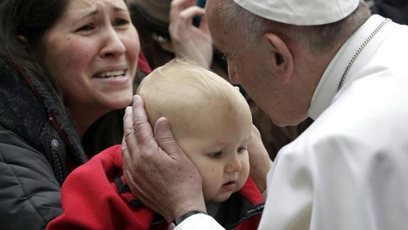 El Papa besa a un niño durante su visita a Suecia.
