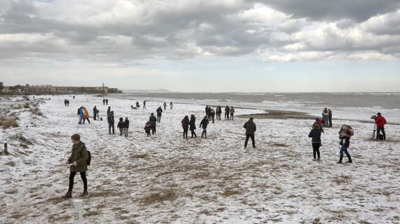 La playa de Denia (Alicante) se llena de gente que juega con la nieve.