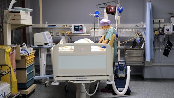 Una enfermera cuida de un paciente en una sala de recuperación.