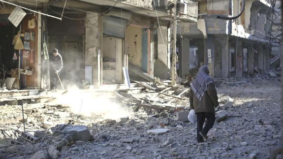 Una persona camina entre las ruinas de una ciudad siria.