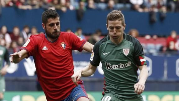 El delantero del Athletic de Bilbao Iker Muniain (d) disputa un balón con el jugador de Osasuna Fran Mérida (i)