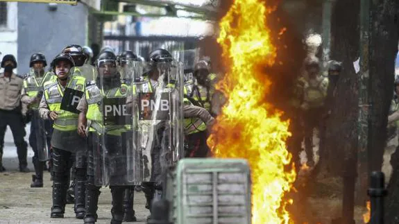 Agentes de la Policía Nacional Bolivariana bloquean el paso de una marcha opositora en Caracas.
