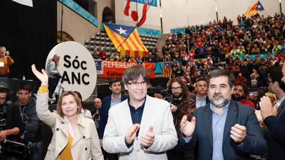 Carles Puigdemont (c), junto al presidente de la entidad soberanista, Jordi Sánchez (d), y la presidenta del Parlament, Carme Forcadell.