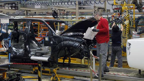 Dos operarios, en una cadena de montaje.