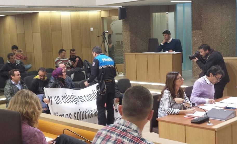 Momento en el que la Policía Local retira una pancarta durante el pleno.