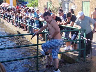 Un jóven sale con una trucha capturada en la manod durante una edición anterior del campeonato de pesca a mano