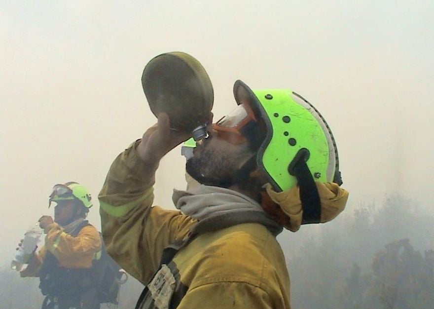 Un brigadista bebe agua durante la extinción de un incendio.