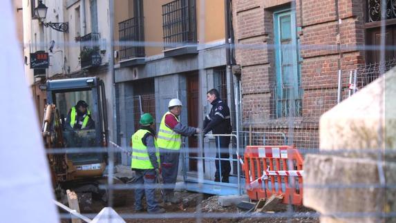 Trabajadores y Policía departen en un momento de la mañana en las obras de la calle Capilla. 