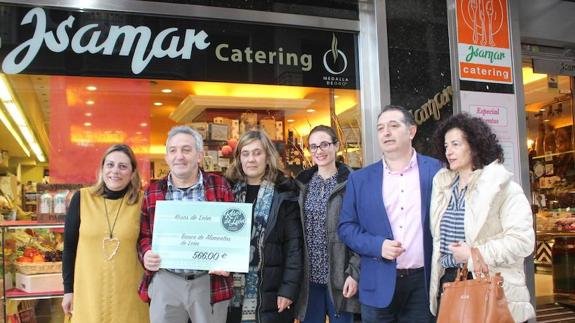 Miembros del Banco de Alimentos, Kesos de León e Isamar, durante la entrega simbólica de la recaudación. 