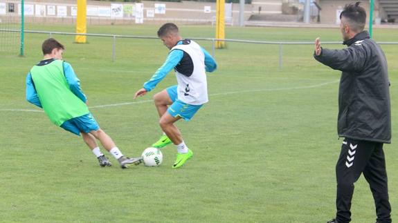 Toni y Bastos pugnan por un balón bajo las órdenes de Rubén de la Barrera.