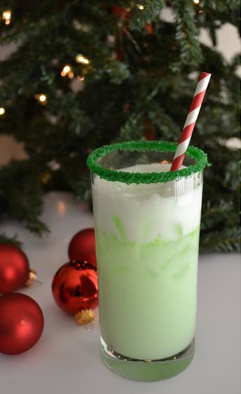 Mezclamos bebida gaseosa con sabor a limón, sorbete de limón y vodka y decoramos el vaso con azúcar verde.