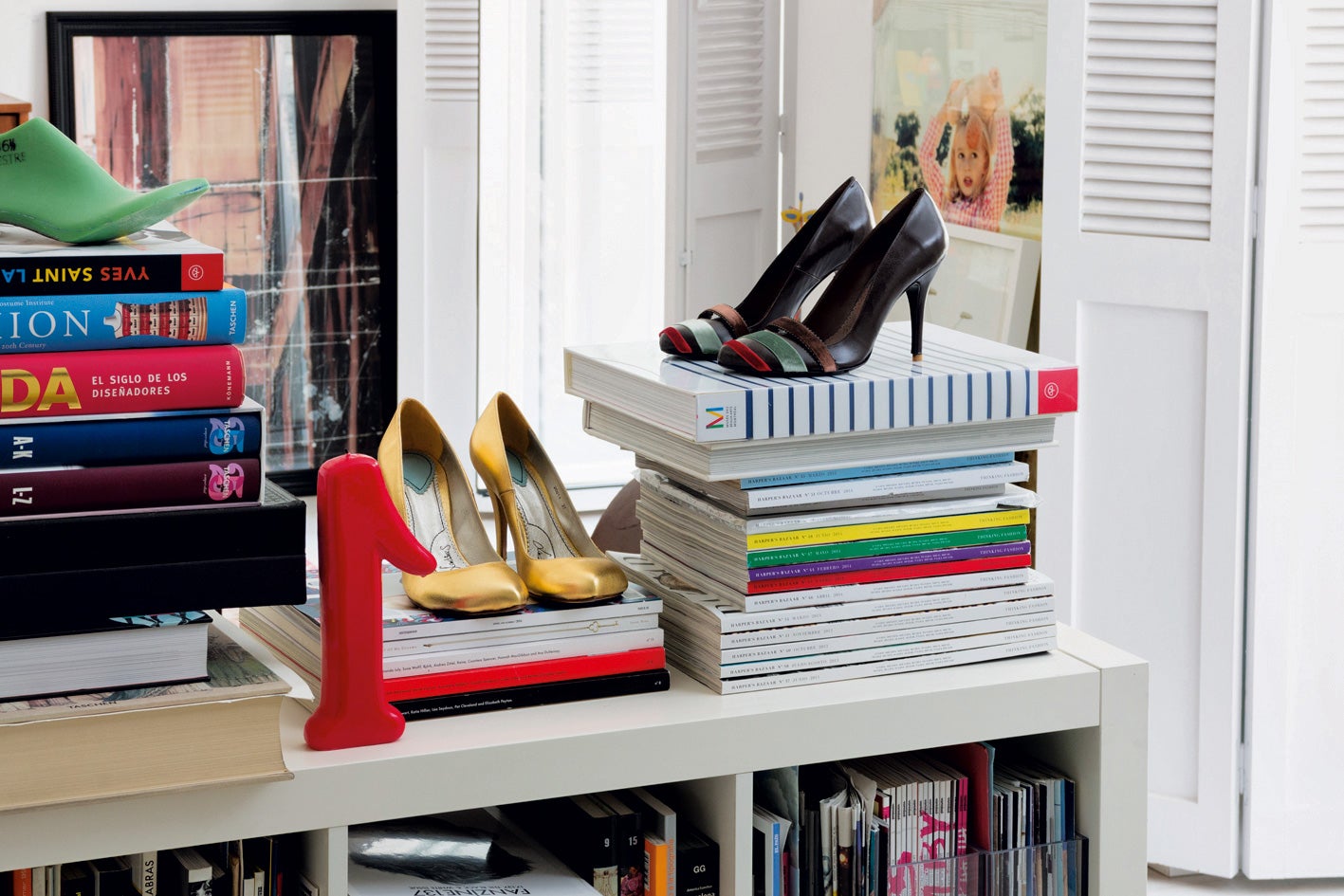 Modelo de Laetitias con tiras de terciopelo, otro par en dorado y una horma de resina verde de la firma.