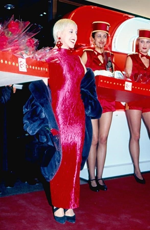 Loles León haciendo gala de su espíritu festivo al lado de unos figurantes vestidos de vendedores de palomitas.