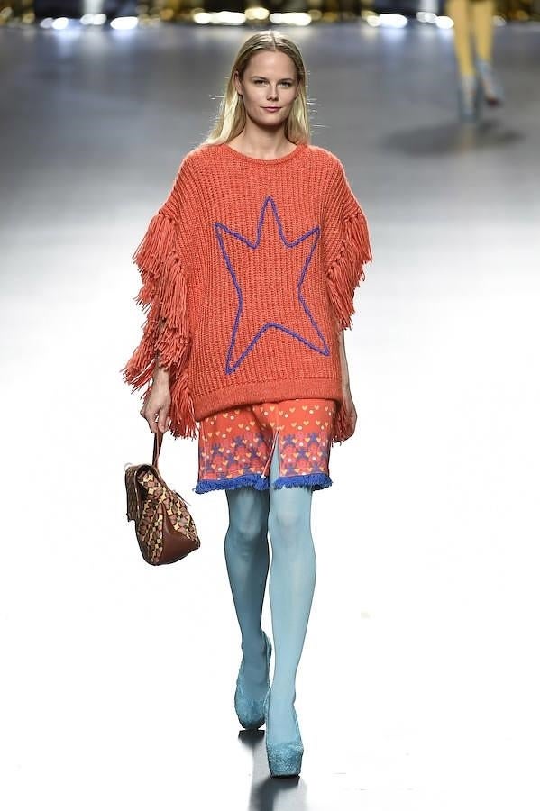 Poncho de color naranja con flecos.