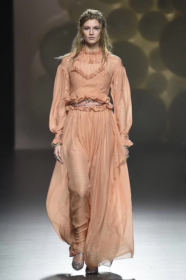 Vestido largo de color salmón decorado con detalles dorados.