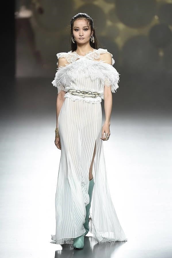 Vestido plisado de color balnco con botas altas de color verde agua.