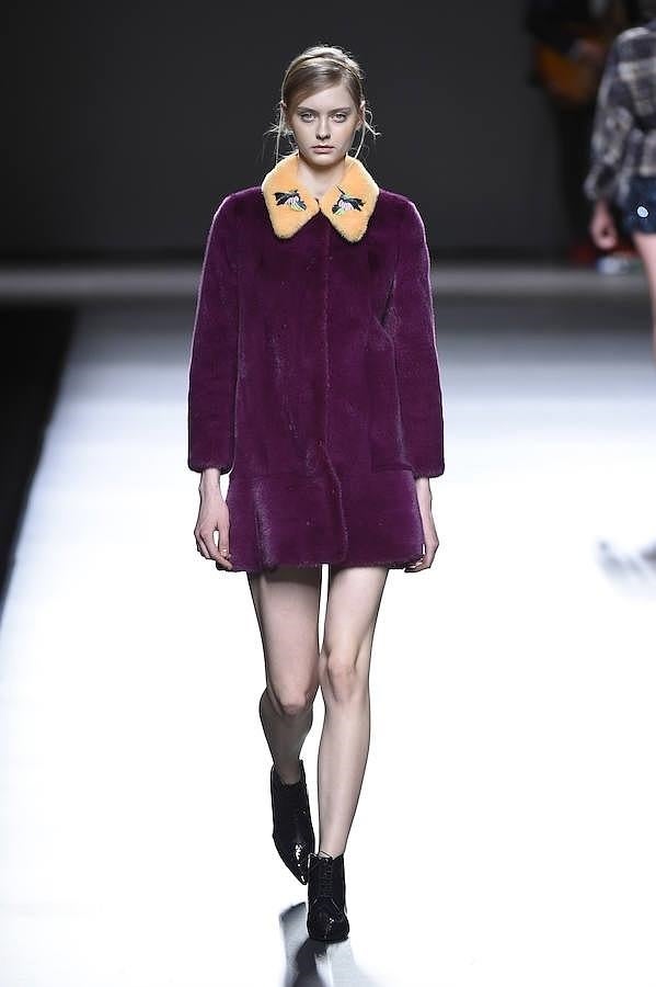 Abrigo de pelo morado con cuello naranja.