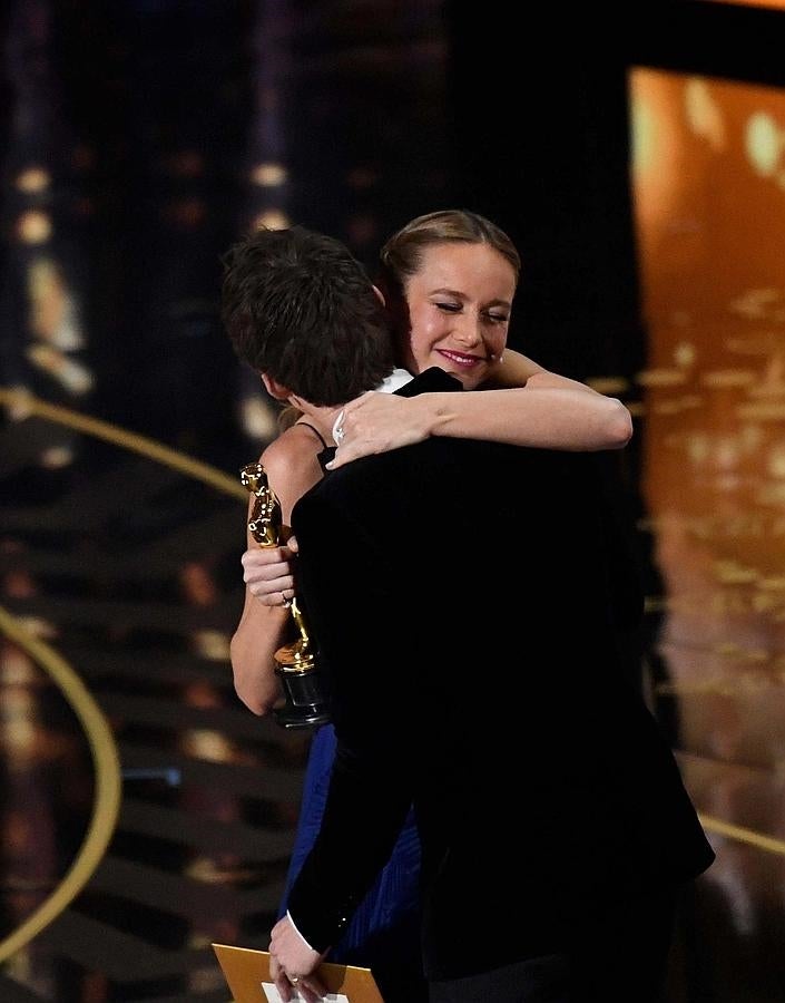 Brie Larson se agarra a Eddie Redmayne sobre el escenrio del Dolby Theatre.