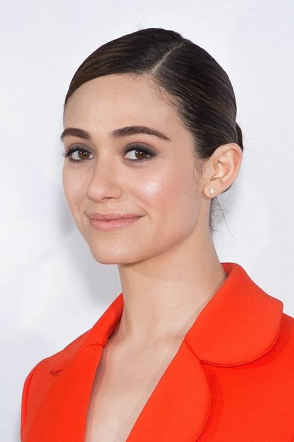 La actriz Emmy Rossum lució el clásico moño de bailarina con raya al lado y acabado pulido en el desfile de Dior en la Semana de la Moda de París.